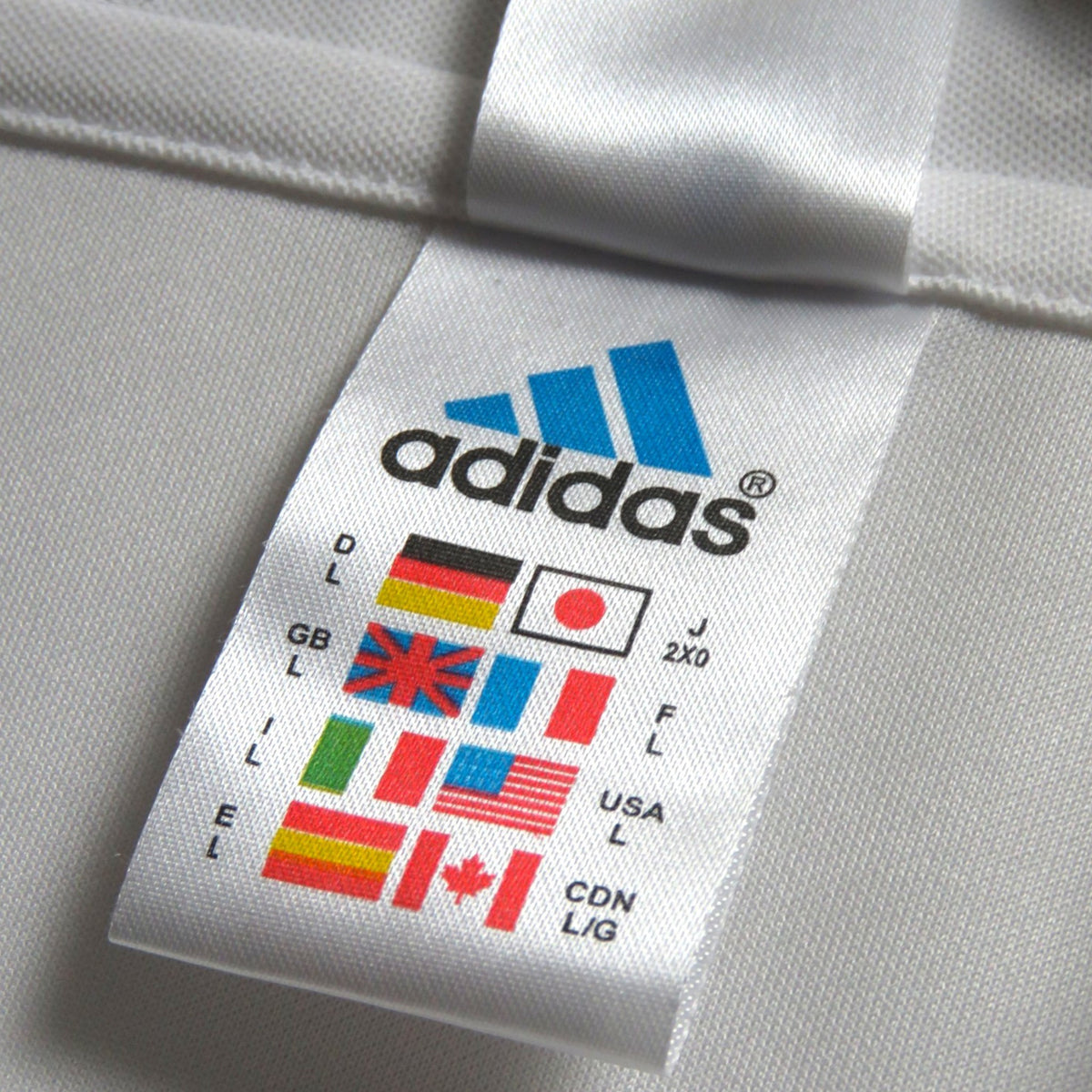Nostalgic Football Shirts wit label van een klassiek wit adidas voetbalshirt uit 2002-03 met maatvoering en vlaggen