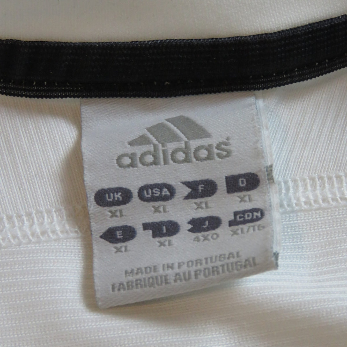 Nostalgic Football Shirts label van een wit Adidas Real Madrid voetbalshirt uit 2003-04 met maat XL aanduiding