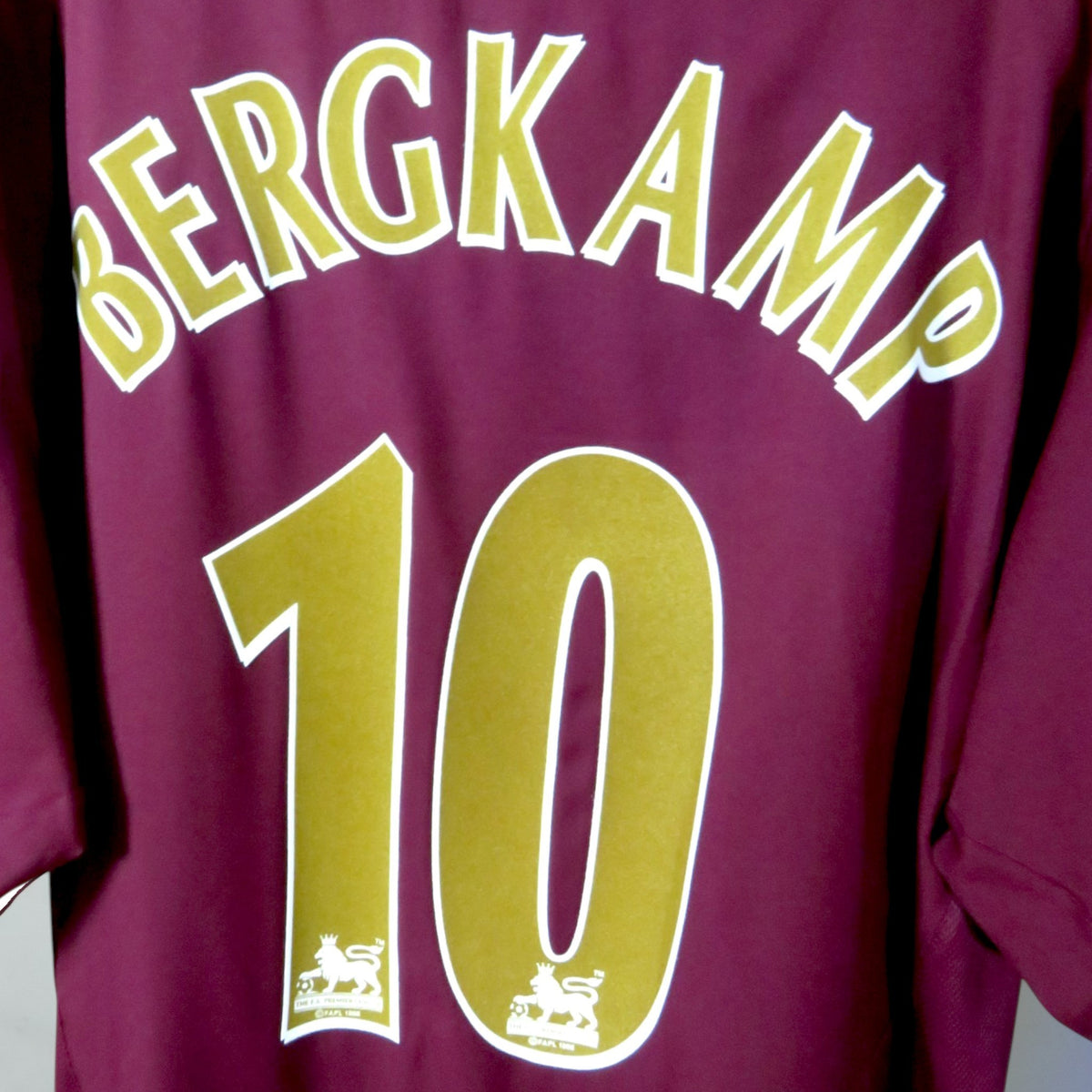Nostalgic Football Shirts Arsenal 2005-06 thuisshirt met Bergkamp 10 bedrukking in goud op bordeauxrode achterkant