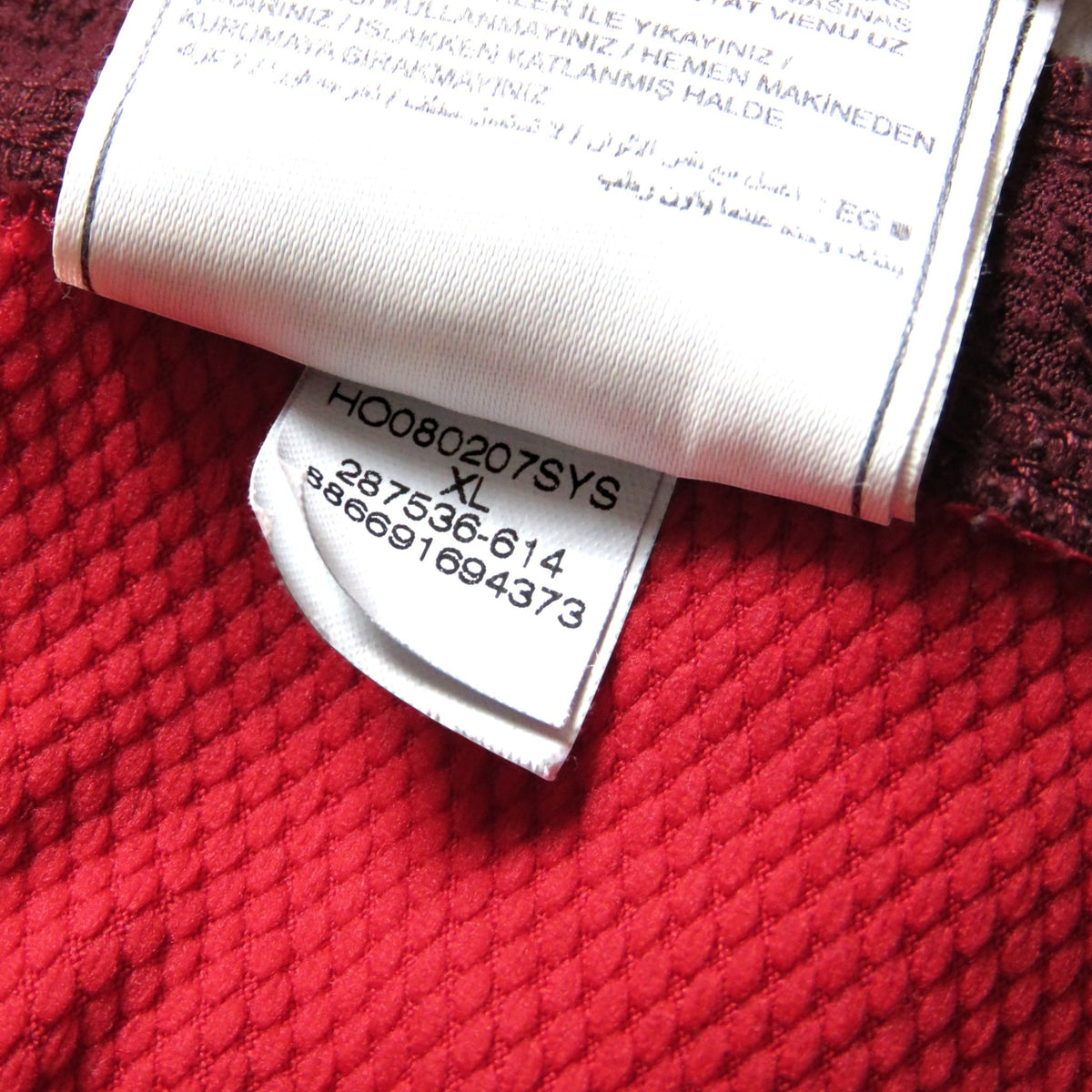 Nostalgic Football Shirts Arsenal 2008-10 thuisshirt label met maat XL en productcode op rode textuurstof