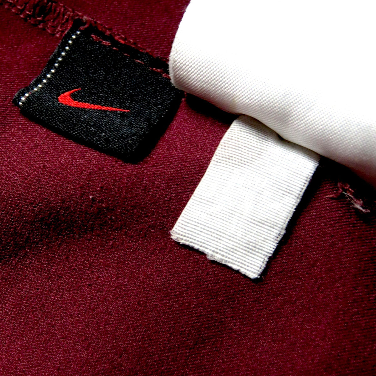 Nostalgic Football Shirts Arsenal 2005-06 thuisshirt detail met Nike logo op bordeauxrode stof