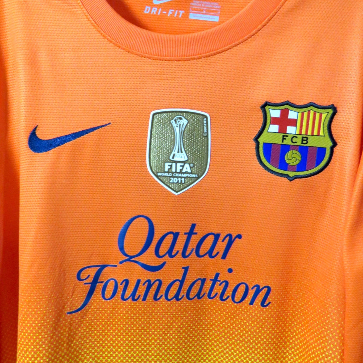 Nostalgic Football Shirts Barcelona 2012-13 uitshirt in oranje met Nike logo, FIFA-badge en Qatar Foundation logo.