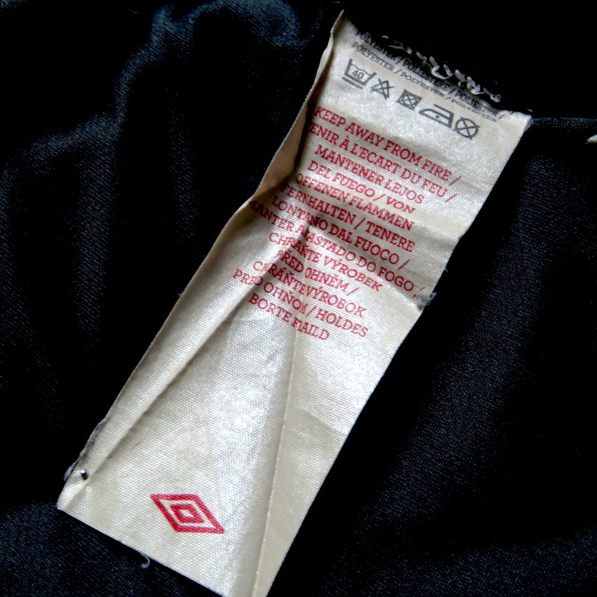 Nostalgic Football Shirts waslabel van een zwart Lille 2012-13 voetbalshirt met Umbro logo en wasinstructies