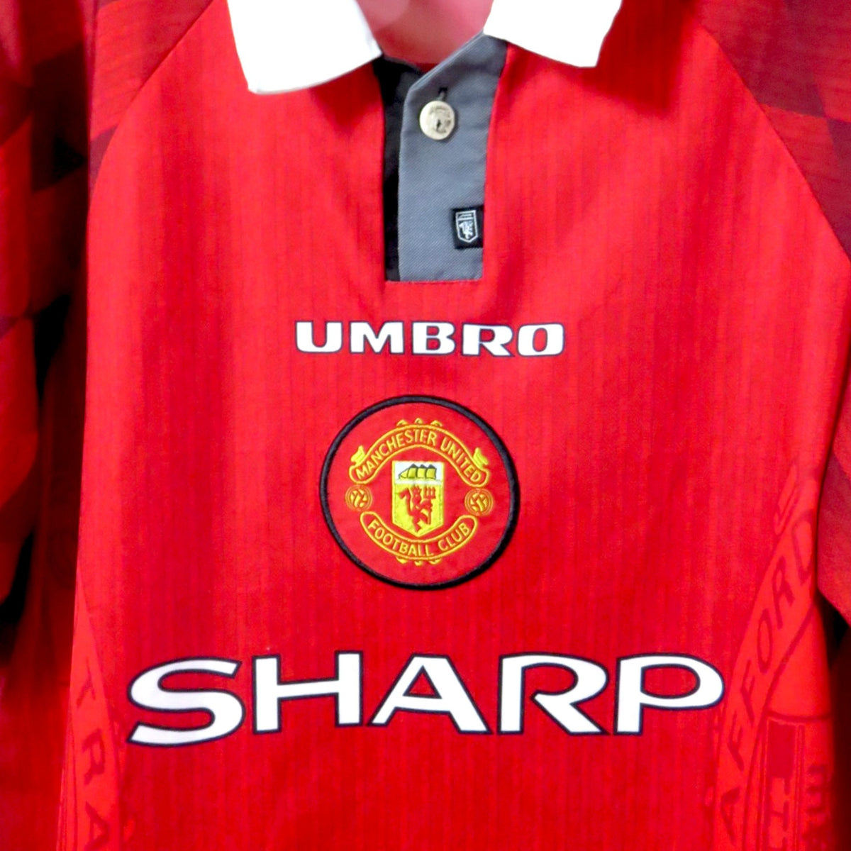 Nostalgic Football Shirts Manchester United 1996-98 thuisshirt in rood met witte kraag, Umbro logo en Sharp sponsor.